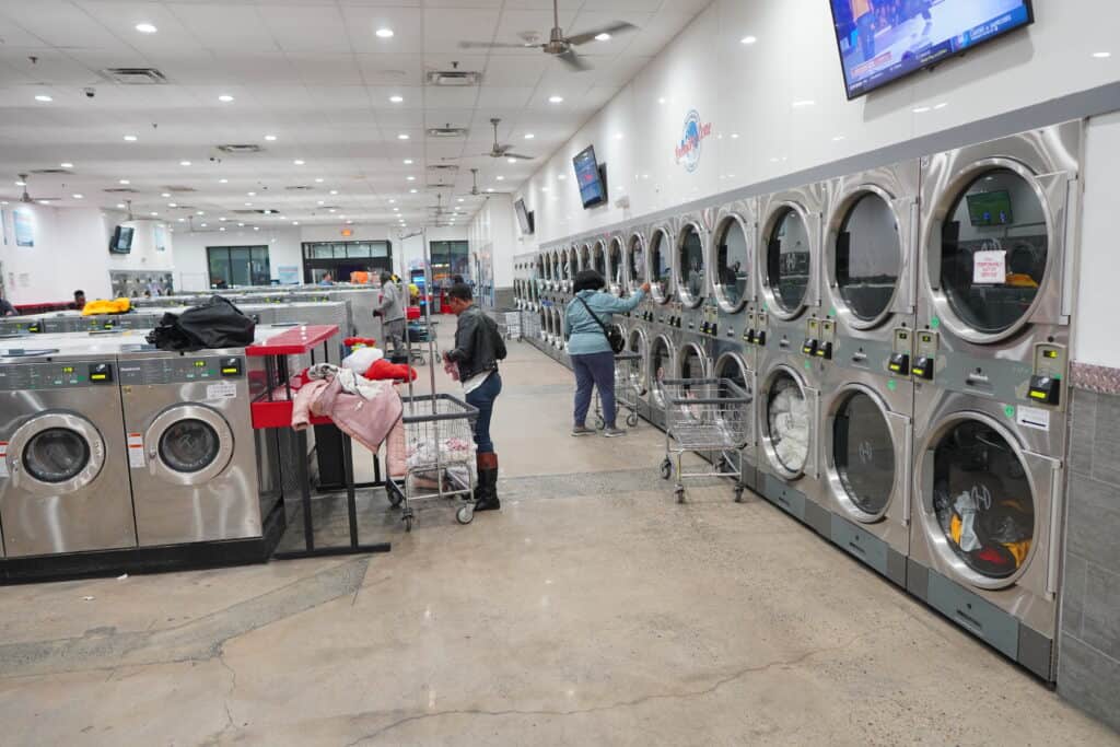 an image of Pennsbury Plaza Laundry Zone machines and busy customers